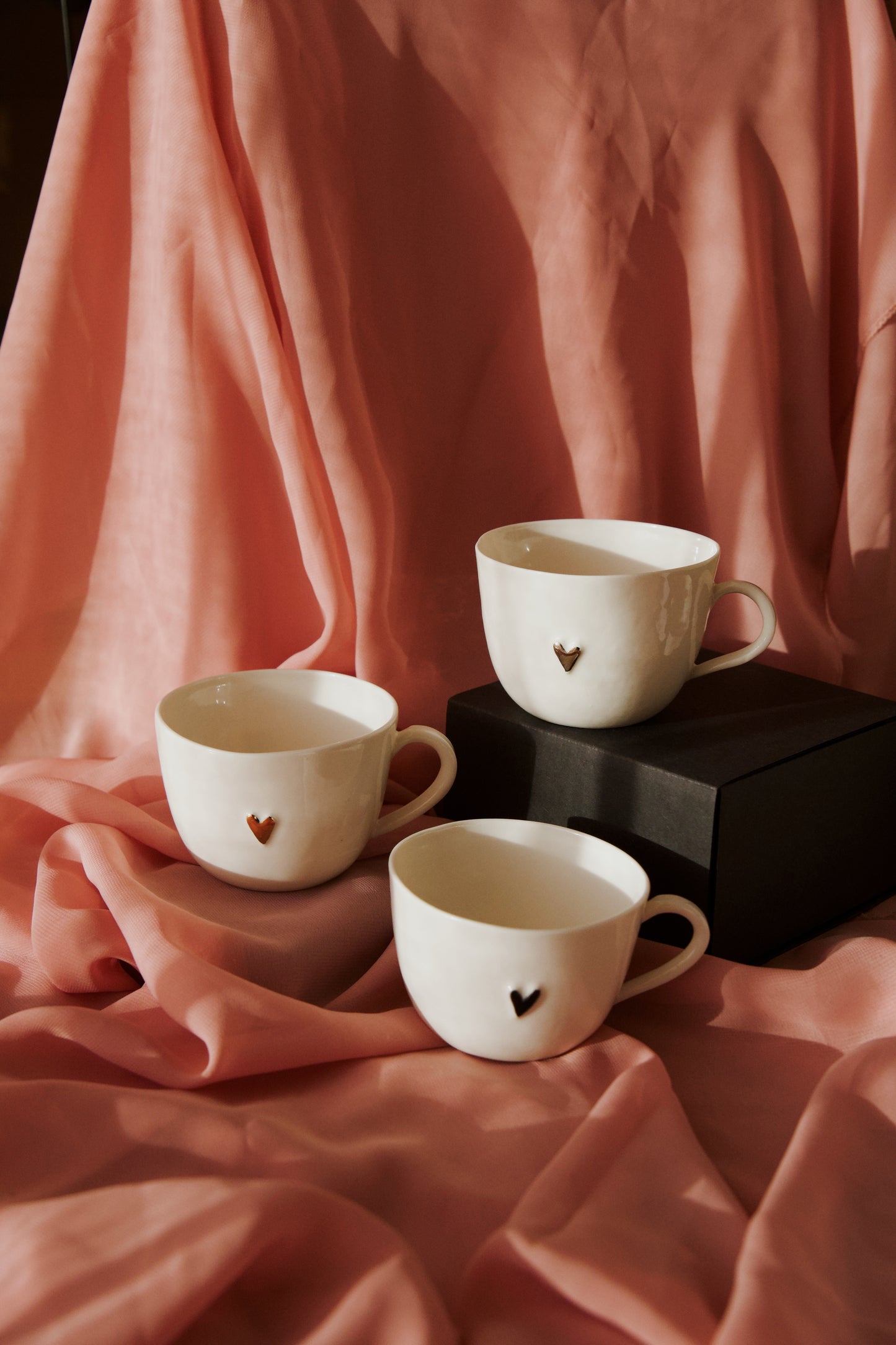 Porcelāna krūzīte ar melnu sirsniņu un apsveikuma kartīti
