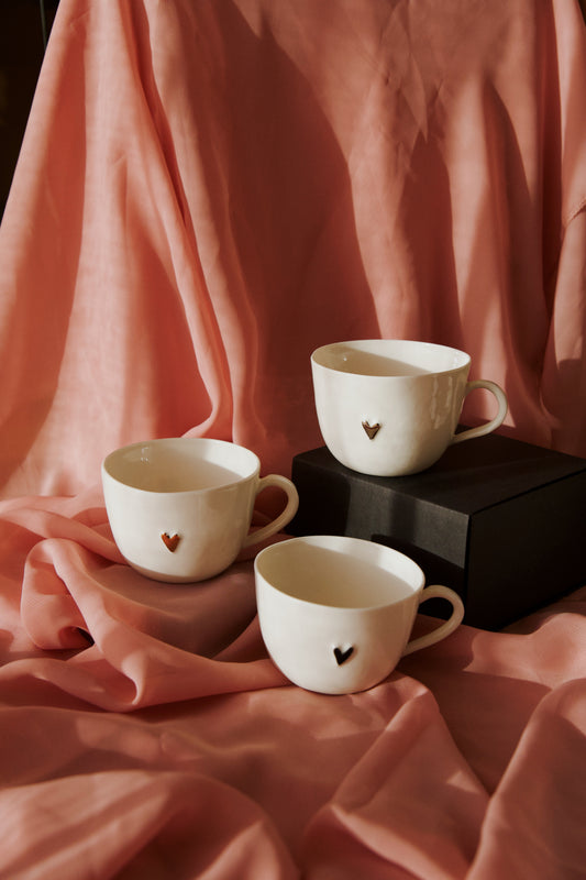 Porcelāna krūzīte ar melnu sirsniņu un apsveikuma kartīti